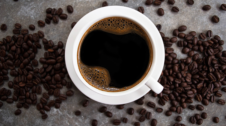 Coffee cup surrounded by beans