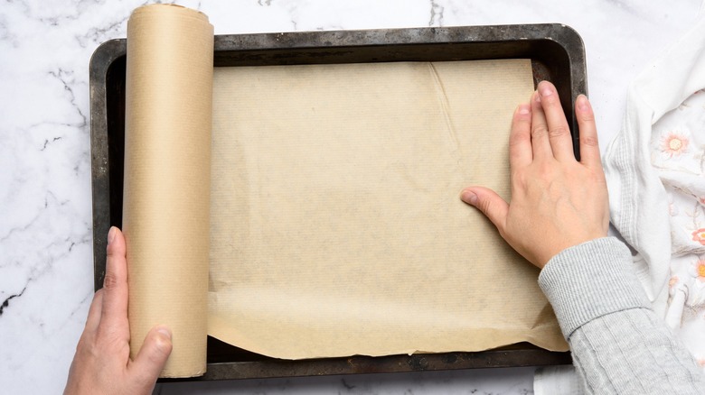 Hands rolling parchment paper