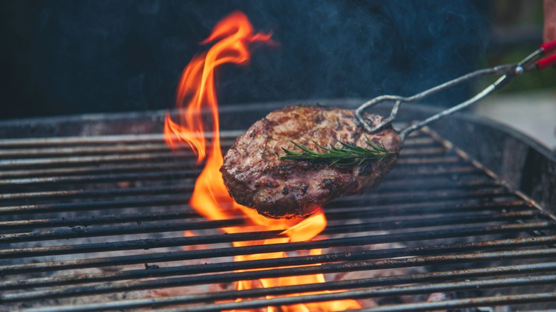 steak grilling over flames