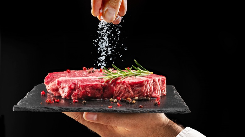 sprinking salt on steak