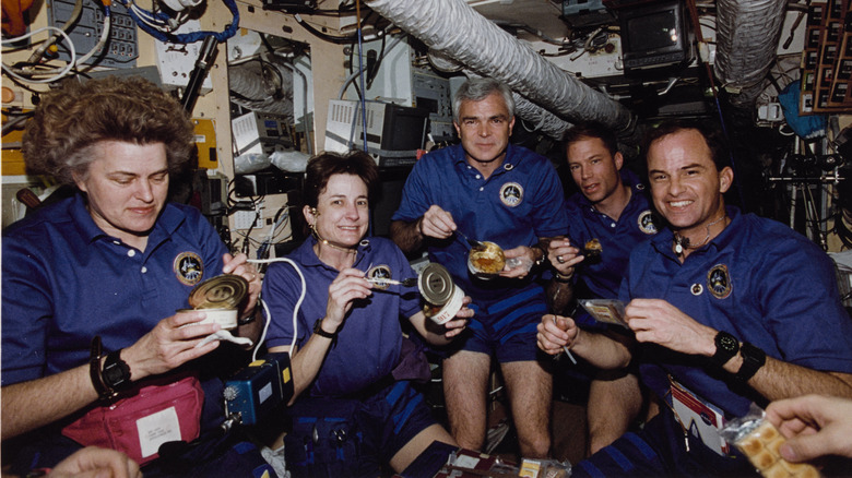 astronauts eating canned food
