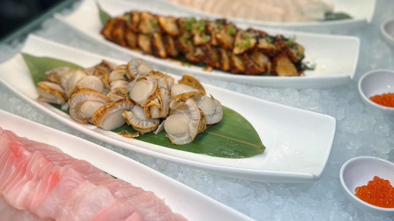 A buffet's sashimi bar with fish and oysters on ice