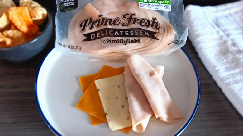 Smithfield deli turkey in package and rolled slices of turkey with flat slices of cheese