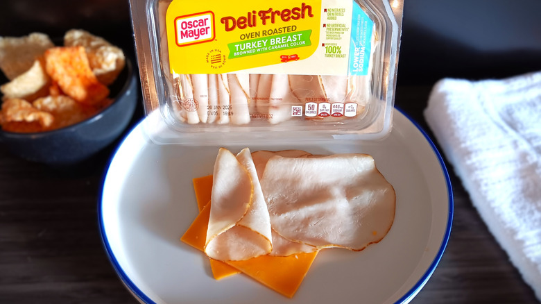 Oscar Mayer deli turkey package with slices on plate, with cheese