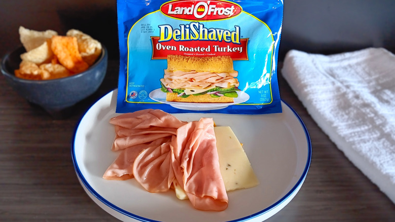 Land O' Frost deli turkey in package with slices on plate