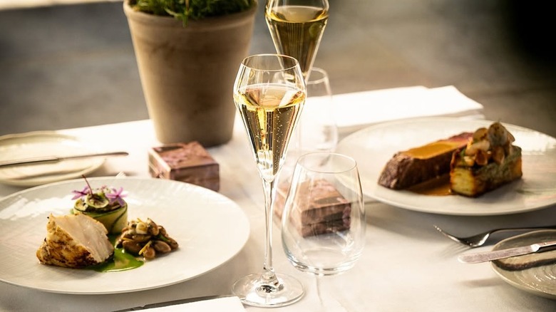 Table set with two dishes and glasses of champagne at Clos Maggiore in London
