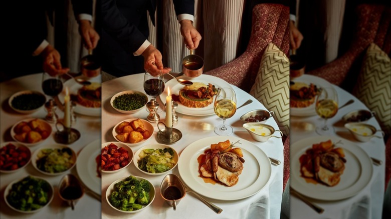 Waiter serving a table filled with various dishes at Dean Street Townhouse