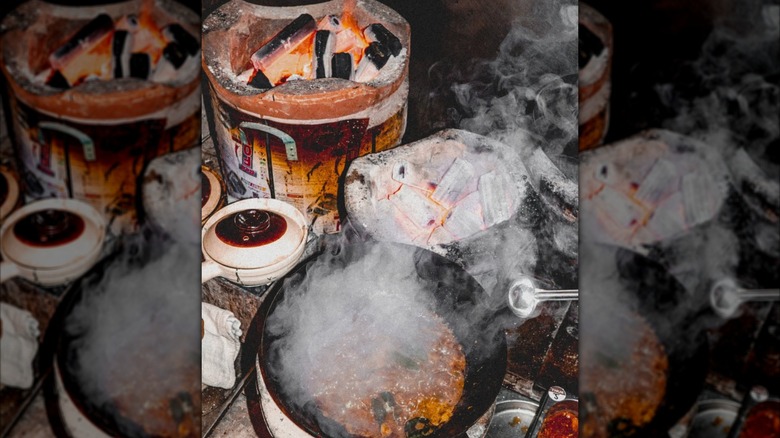 Thai dish getting cooked over open wood fire at Kiln Soho