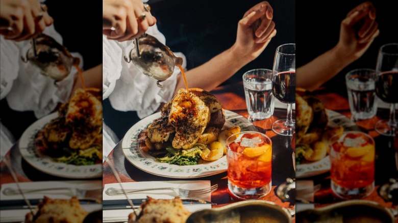 Waiter pouring gravy over a sunday roast dinner at The Blaclock in London