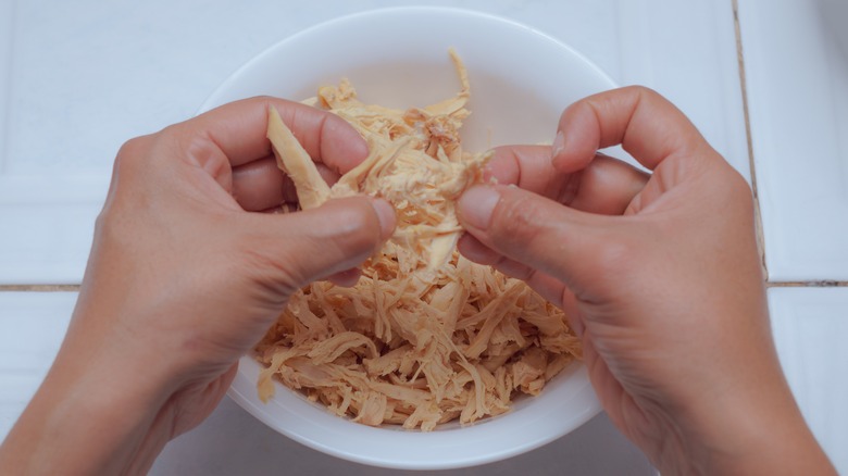 hands shredding meat