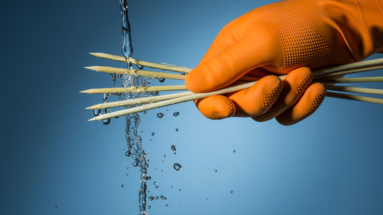 wood skewers under running water