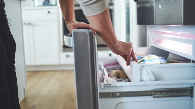 Man looking into freezer drawer