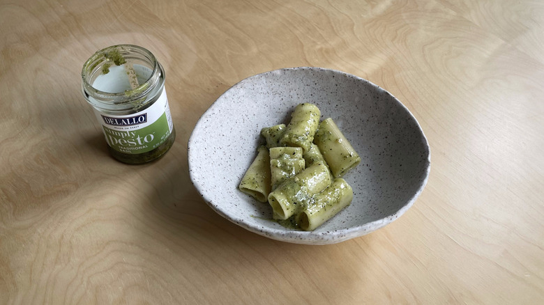 pesto jar next to pasta bowl 