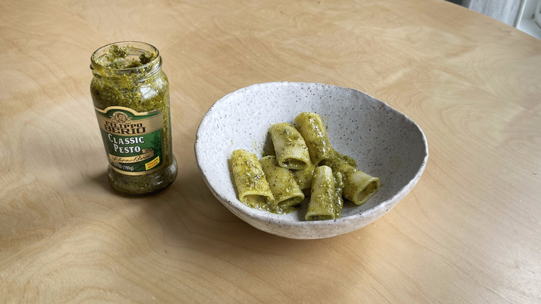 pesto jar next to pasta bowl 