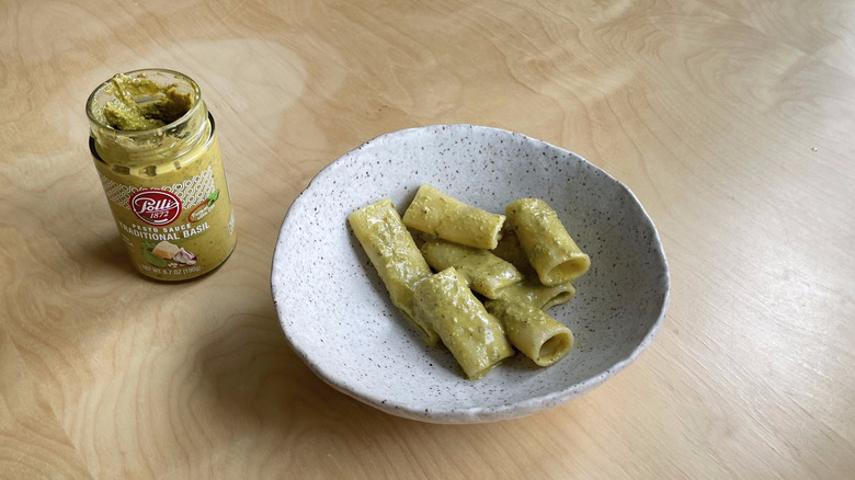 pesto jar next to pasta bowl 