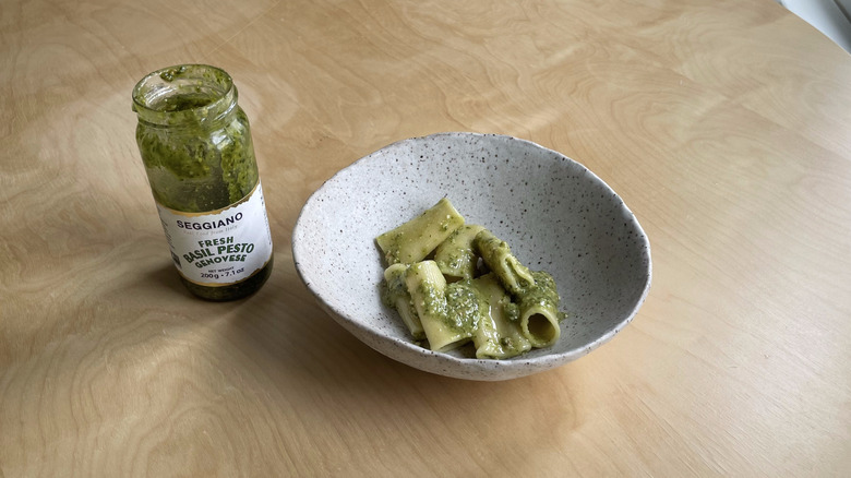 pesto jar next to pasta bowl 