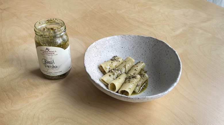 pesto jar next to pasta bowl 