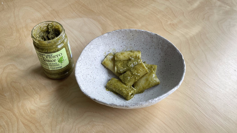 pesto jar next to pasta bowl 