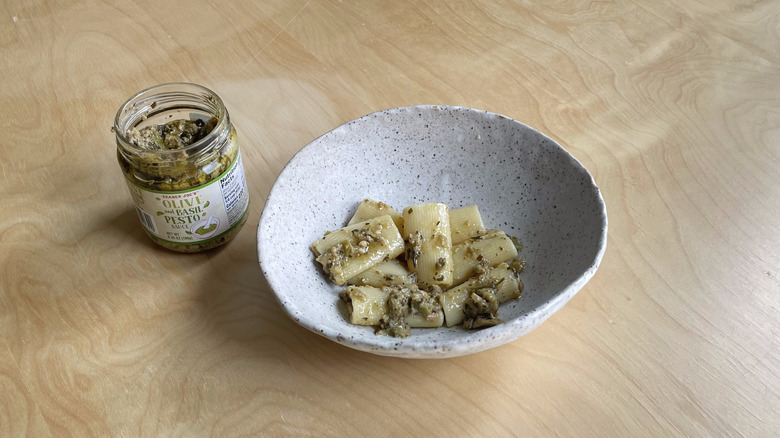 pesto jar next to pasta bowl 