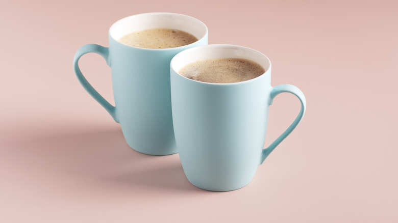 Two light blue mugs against light pink background