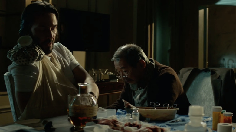 Keanu Reeves drinking Blanton's bourbon at a table in the movie John Wick