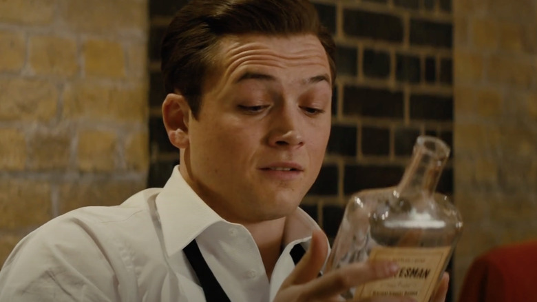 Taron Egerton looking at a bottle of Old Forester Statesman in the movie Kingsman: The Golden Circle