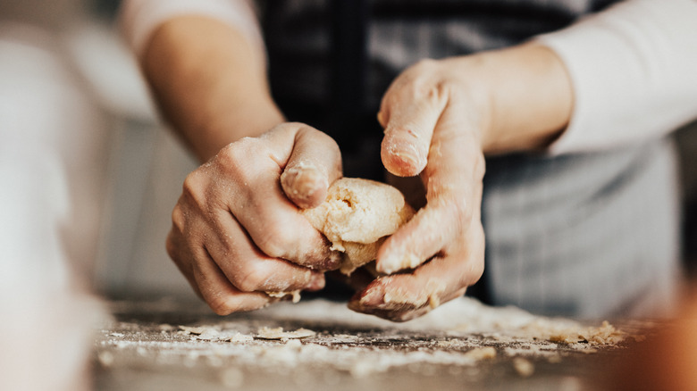 Close up of women's hands kneading dough 