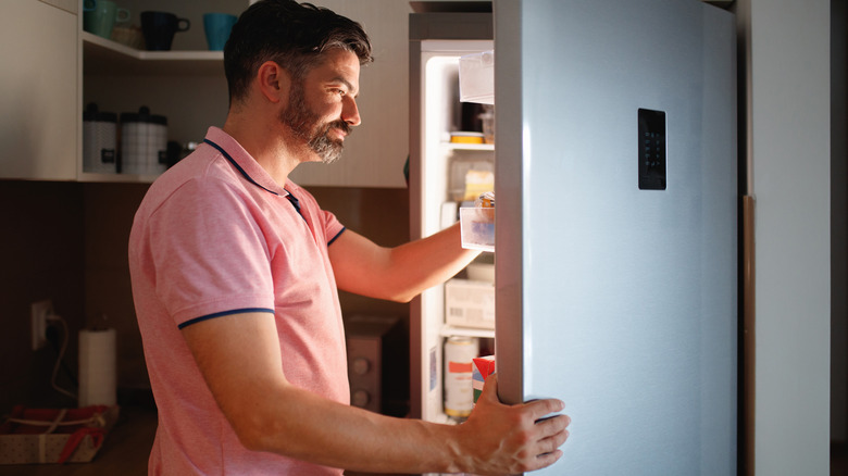 Man looks into refrigerator 