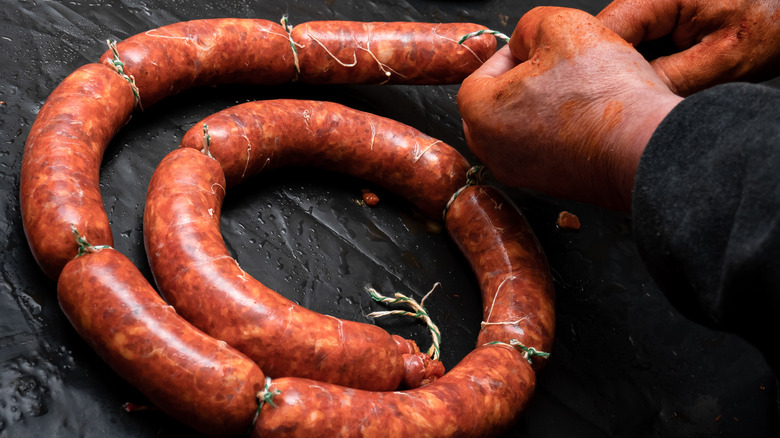 Hands of a person making chorizo sausages