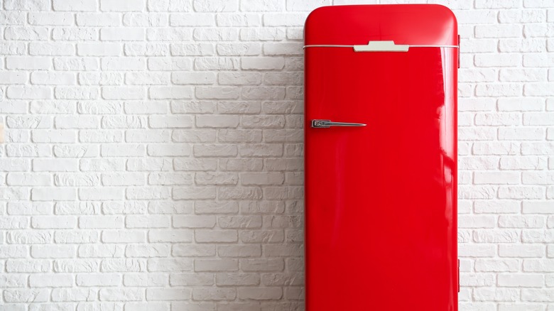 Red fridge on white wall