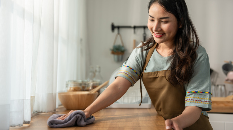 Woman cleaning kitchen surface