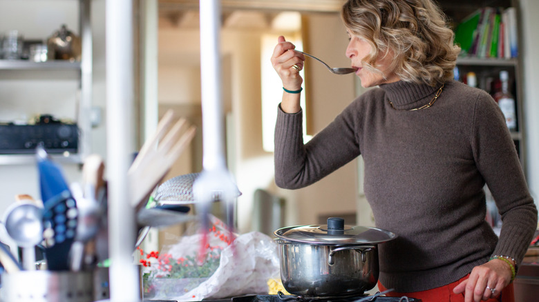 Woman tasting cooking with spoon