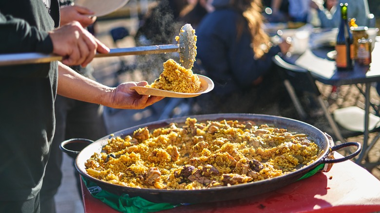 man serving paella