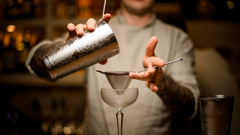 person double straining cocktail