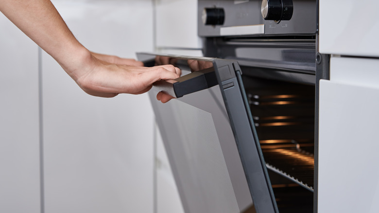 Hands holding oven door