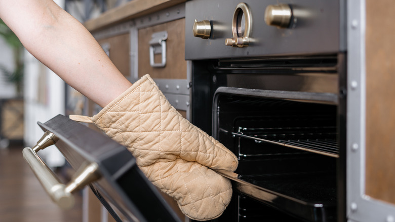 Oven mitt grabbing baking sheet