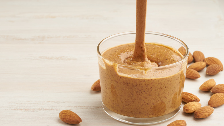 stirring almond butter in jar