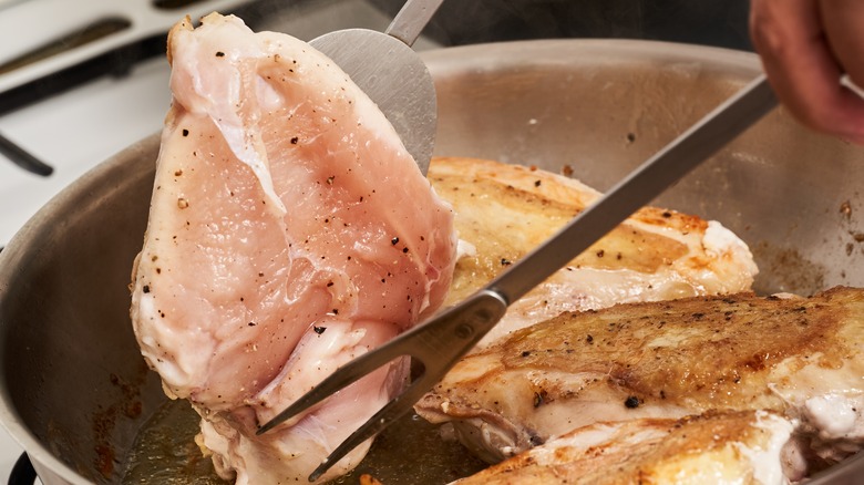 Chicken breasts in stainless steel pan