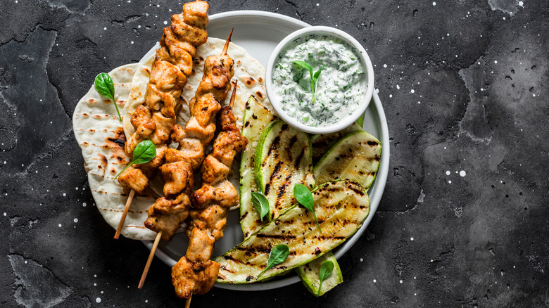 grilled zucchini with chicken skewers, pita, and dip