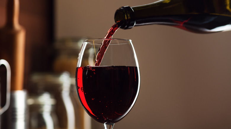 Bottle pouring red wine into glass