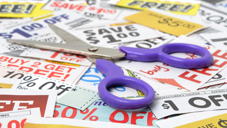 Purple scissors on pile of coupons