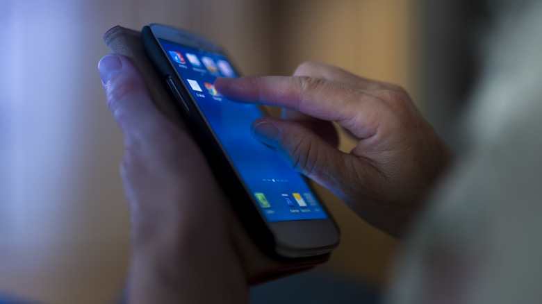 Hands holding a phone with finger opening app