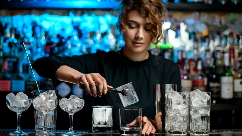 Woman grabbing ice with tongs