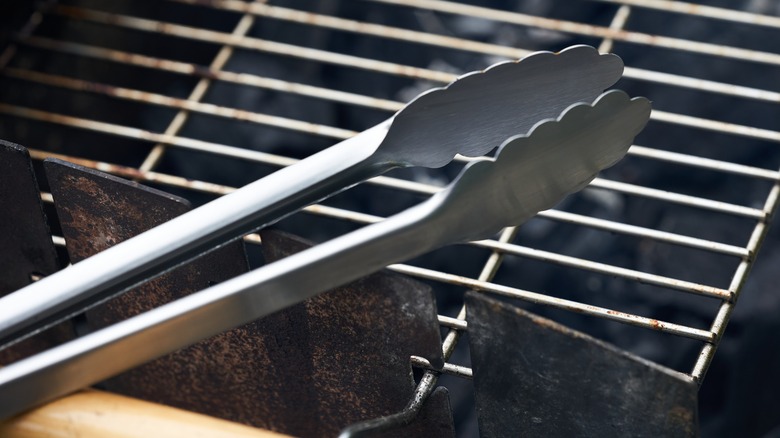 Stainless steel tongs over grill