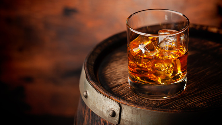 Glass of bourbon on a barrel