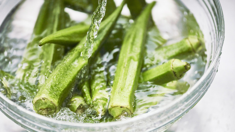 Okra soaking in a glass bowl