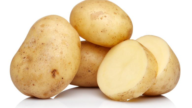 Raw potatoes against white background