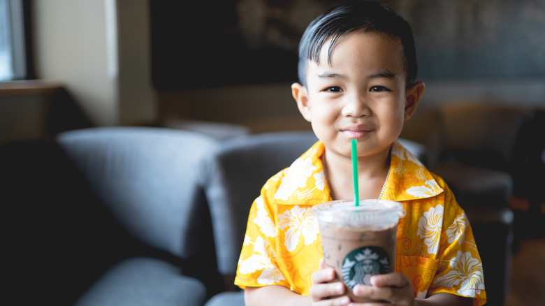 kid holding starbucks