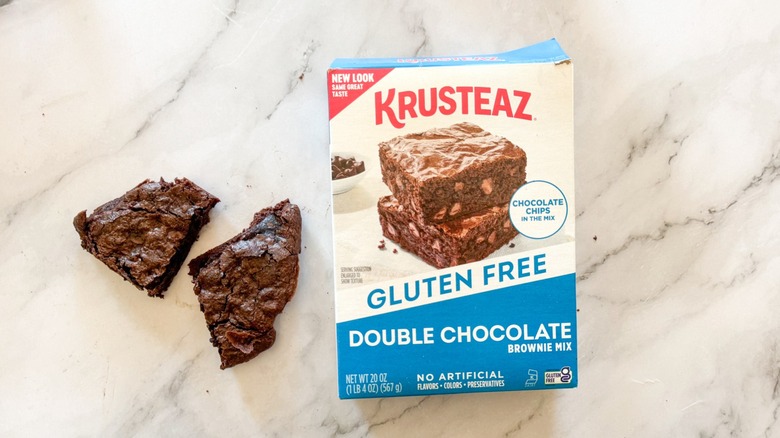 Krusteaz gluten-free double chocolate baking mix with brownie on marble surface