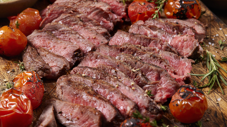 Rare sliced flank steak with roasted tomatoes